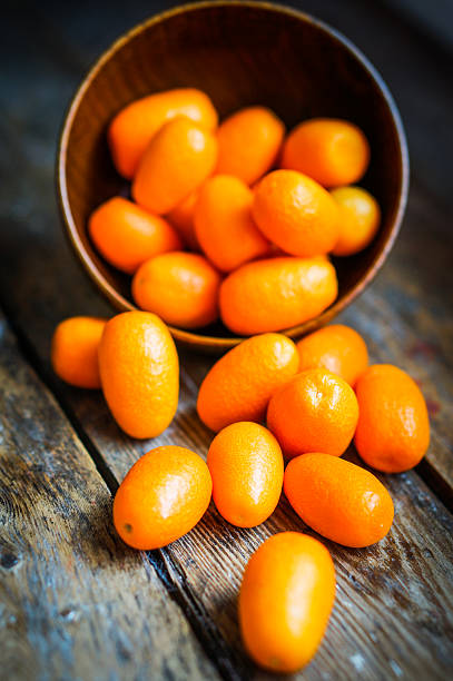 istock Kumquat in a bowl on rustic wooden table 469684355