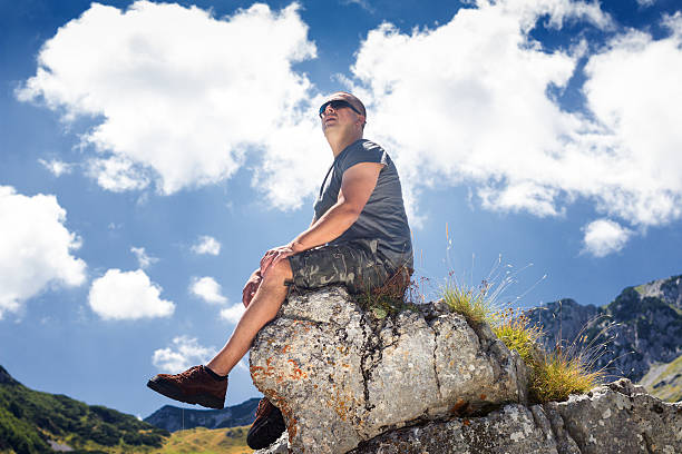 istock Man sitting on rock against natural background 469685218