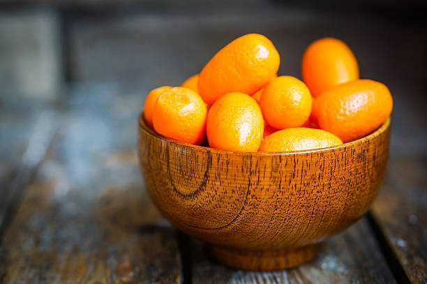 istock Kumquat in a bowl on rustic wooden table 469688877