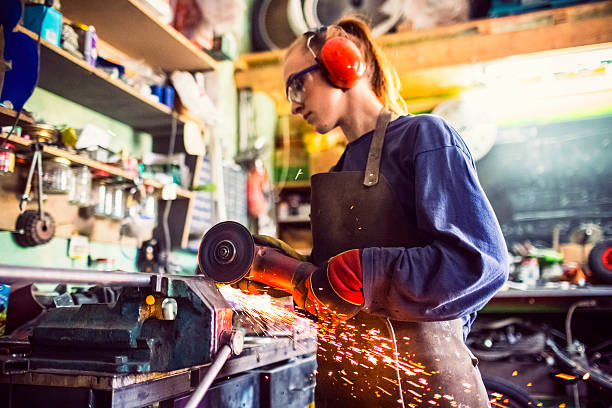 istock Young woman cutting iron bar in workshop 469691618