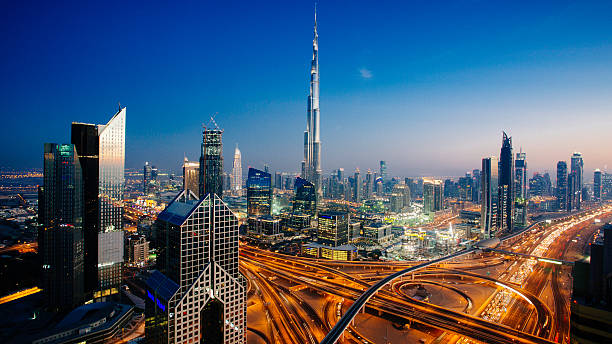 Dubai sky line with traffic junction and Burj Khalifa Dusk view of awesome Dubai's sky line, Aerial view of the city at blue hour. united arab emirates photos stock pictures, royalty-free photos & images