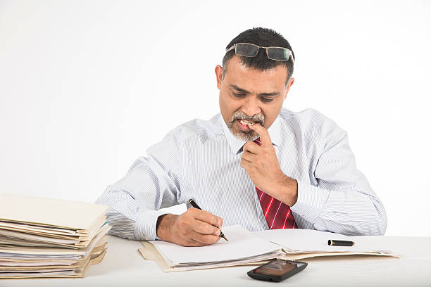 empresario trabajador de oficina nervioso morder sus uñas en el escritorio - nail biting guilt men anxiety fotografías e imágenes de stock