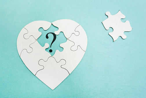 Heart shaped puzzle with question mark in missing piece