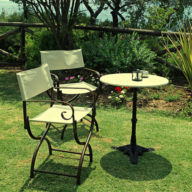 istock Table and iron chairs on green grass in the garden 469703218