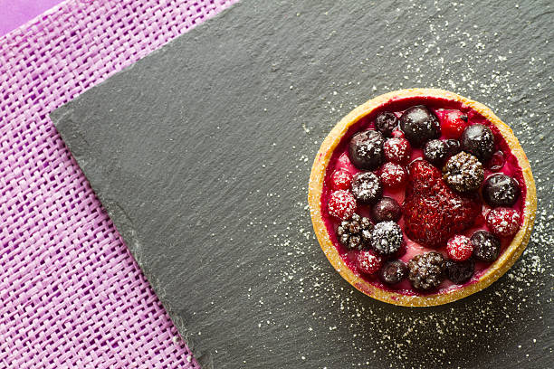 Autumn fruit cake on a slate plate on purple background