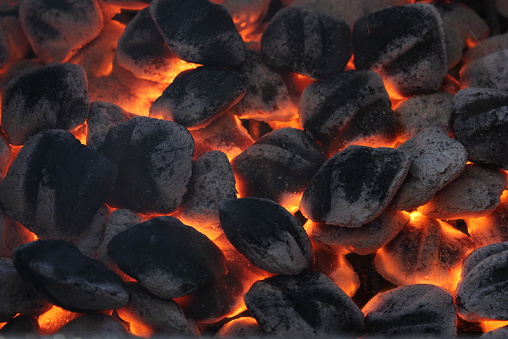 Many charcoal briquettes glowing in a barbecue