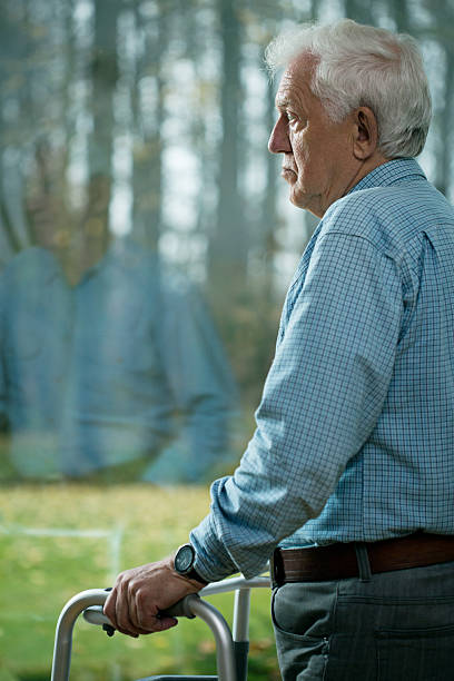 istock A old man with a walking frame staring out of a window 469709312