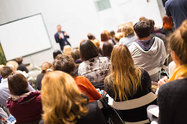 Audience in the lecture hall. Speaker Giving a Talk at Business Meeting. Audience in the conference hall. Business and Entrepreneurship. Copy space on white board. public speaker photos stock pictures, royalty-free photos & images