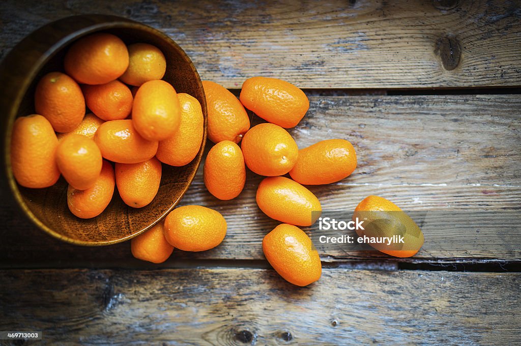 Kumquat in a bowl on rustic wooden table Kumquat Stock Photo