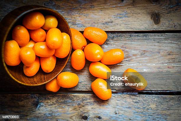 Kumquat In A Bowl On Rustic Wooden Table Stock Photo - Download Image Now - Kumquat, Backgrounds, Basket