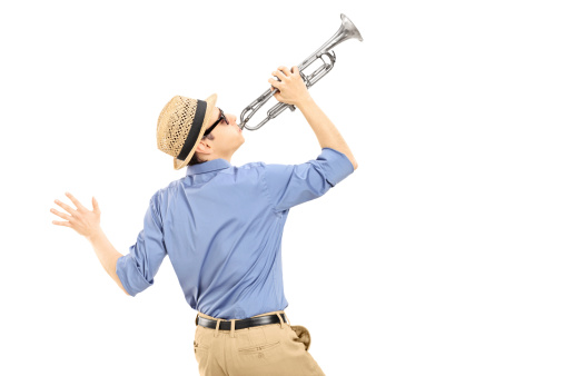 Excited young musician playing trumpet isolated on white background, rear view