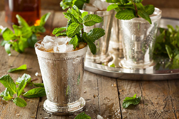 A frosty mint julep in a metal cup with a mint garnish  Refreshing Cold Mint Julep for the Derby mint julep photos stock pictures, royalty-free photos & images