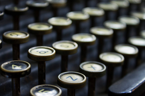 Photograph of an antique typewriter keys, focus on the foreground keys A, Z, 4 and 5.