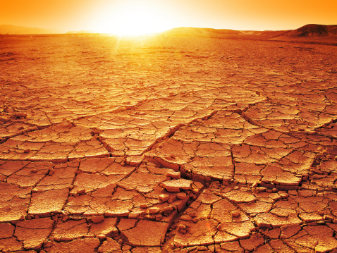 Golden sunset at a desert. Dry and thirsty soil.