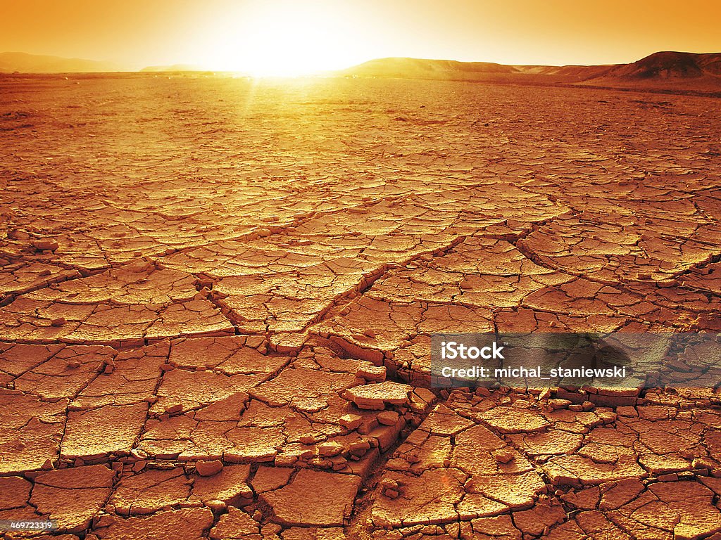 Sunset at a desert Golden sunset at a desert. Dry and thirsty soil. Desert Area Stock Photo