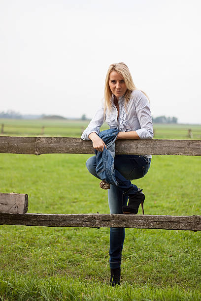 istock Young woman by fence 469730349