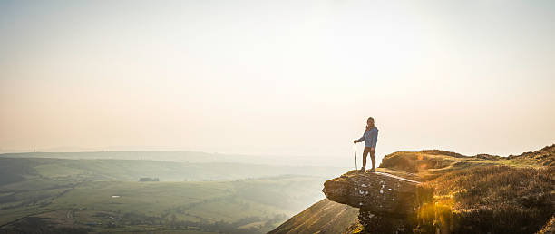 istock Young hiker looking out over mountain valley misty dawn panorama 469732884