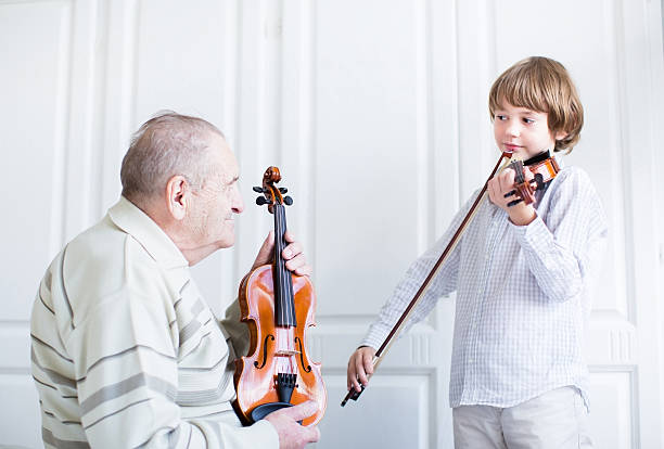bisabuelo escucha un niño tocando violín - violin family fotografías e imágenes de stock