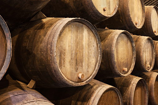 Stacked wooden wine barrels in Porto 