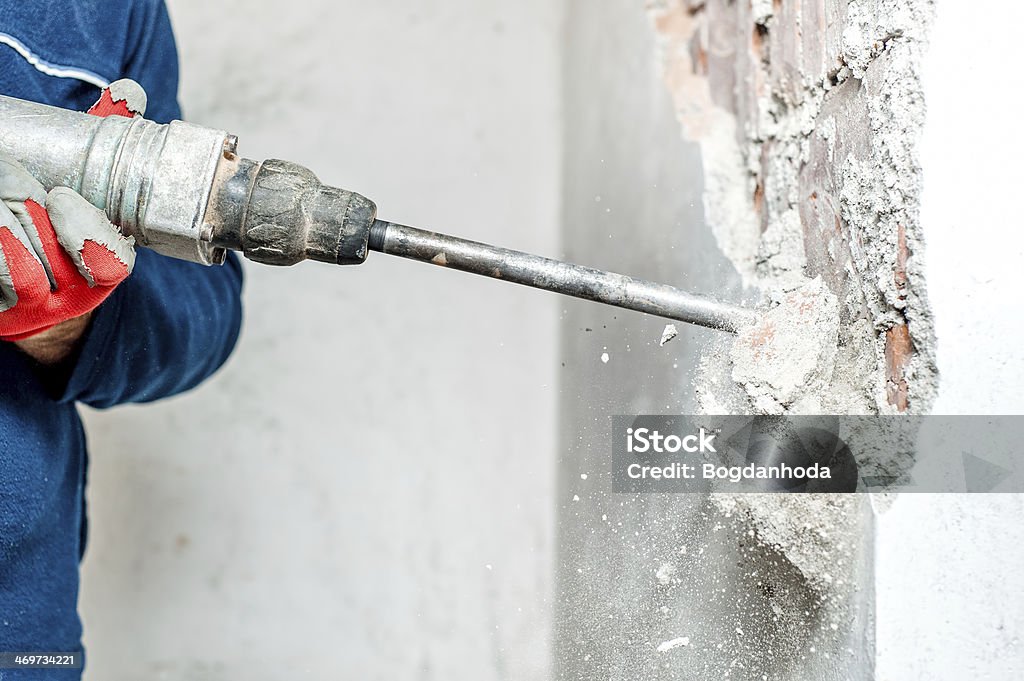 Mann benutzt einen Presslufthammer um den drill in der Wand - Lizenzfrei Abbrechen Stock-Foto