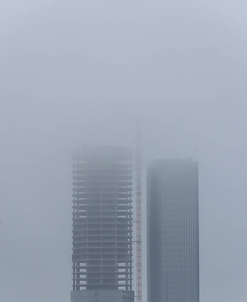 deux grandes gratte-ciel en construction entouré de smog - beijing air pollution china smog photos et images de collection