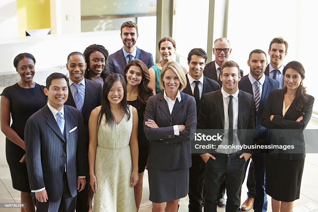 Multi-cultural office staff standing in lobby Portrait Of Multi-Cultural Office Staff Standing In Lobby Smiling At Camera Multiracial Group Stock Photo