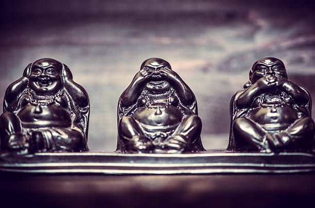 Three figures of Buddha philosophy on wooden background