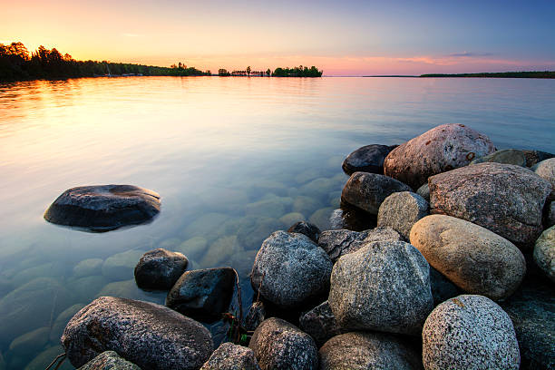 Large boulders on lake shore at sunset. Minnesota, USA Large boulders on lake shore at sunset. Minnesota, USA boulder rock photos stock pictures, royalty-free photos & images