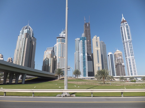 Dubai, UAE - December 21, 2011: Sheikh Zayed Road skyscrapers in Dubai, UAE. The Sheikh Zayed Road (E11 highway) is home to most of Dubai's skyscrapers, including the Emirates Towers.