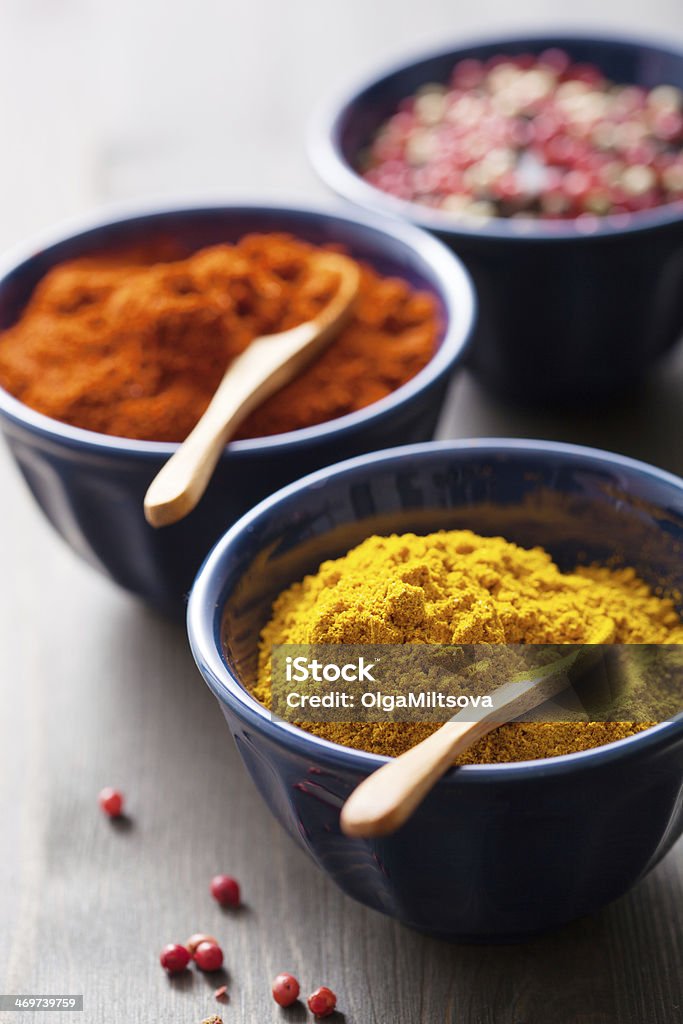 spices in bowls: curry, pink and black pepper, paprika powder Black Color Stock Photo