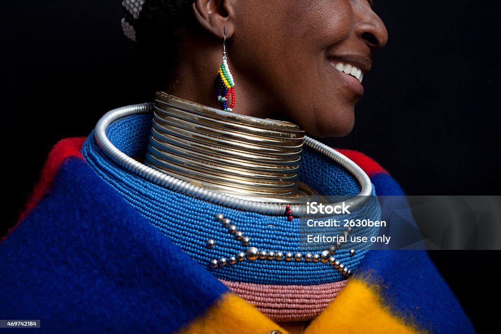 Ndebele Smile Pilgrims Rest, South Africa - July 13, 2011: A Ndebele woman sits in front of a shop in Pilgrims Rest South Africa. The women sit here on a daily basis asking for money for photos. Questioned further why they do it they say that it helps them preserve their culture. It shows their children that they can still live a traditional lifestyle and stay true to their culture. South Africa Stock Photo