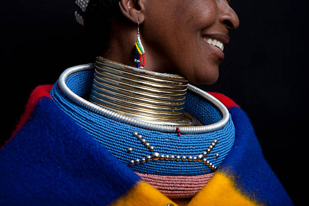 Ndebele Smile Pilgrims Rest, South Africa - July 13, 2011: A Ndebele woman sits in front of a shop in Pilgrims Rest South Africa. The women sit here on a daily basis asking for money for photos. Questioned further why they do it they say that it helps them preserve their culture. It shows their children that they can still live a traditional lifestyle and stay true to their culture. african tribe stock pictures, royalty-free photos & images