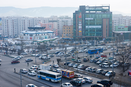 Ulaanbaatar, Mongolia - January 23, 2015: vehicles and people at the busy intersection known as East Cross Road, on the eastern side of Peace Avenue. Scene shot on a freezing winter evening.