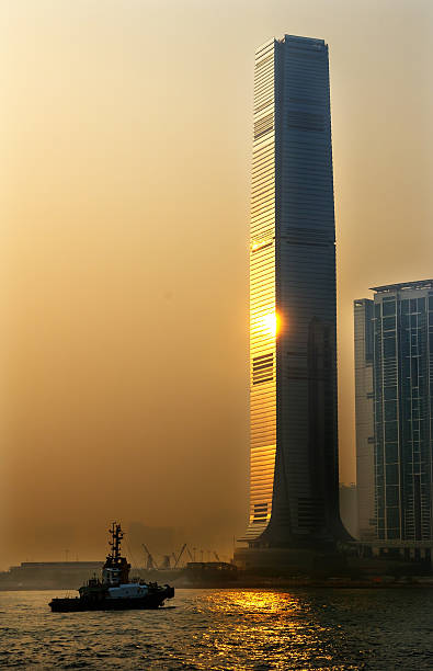 International Commerce Center ICC Building Kowloon Hong Kong Harbor Hong Kong S.A.R. - May 28, 2011: Inernational Commerce Center ICC Building Kowloon Hong Kong Harbor Tugboat, Sunset 4th Largest Building in the World international commerce center stock pictures, royalty-free photos & images