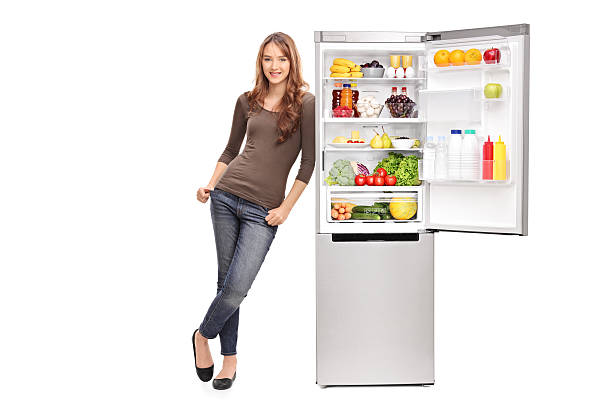 Casual young girl leaning on an opened refrigerator