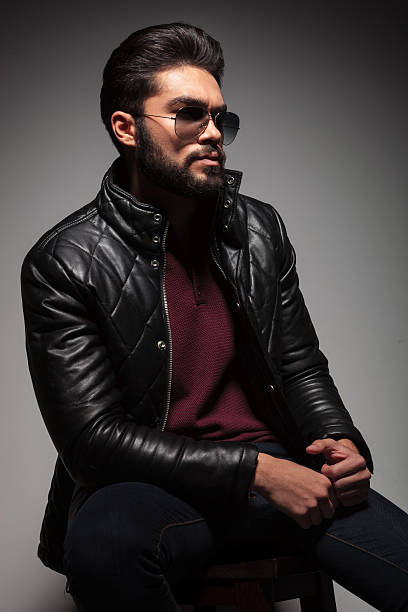 istock seated young man in leather jacket and sunglasses 469743723