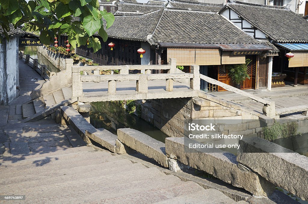 The famous Twin Bridge in Zhouzhuang water town near Shanghai Shanghai, China - August 9, 2013: A sunny summer day at the famous Twin Bridge (two connected stone bridges built in the Wanli period (1573-1619) of the Ming Dynasty) in Zhouzhuang - a water town situated on the outskirts of Shanghai. Ancient Stock Photo