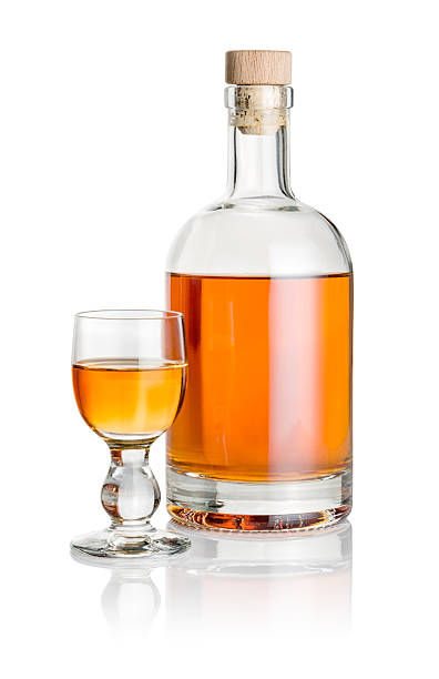 istock Bottle and glass goblet filled with amber liquid 469750510