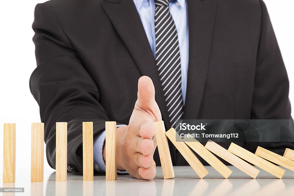 businessman hand stop dominoes continuous toppled businessman hand stop dominoes continuous toppled on the desk Risk Stock Photo