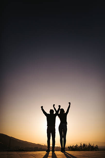 istock Silhouette of couple with arm raised 469753902