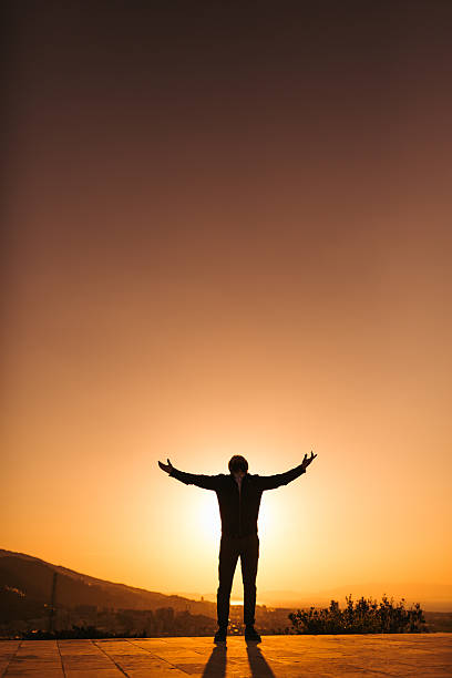 Silhouette of man with arm raised.