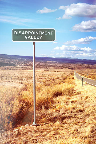 istock Road Sign Reading DIsappointment Valley 469754202
