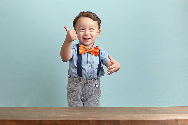 Portrait of happy little boy giving you thumbs up stock photo
