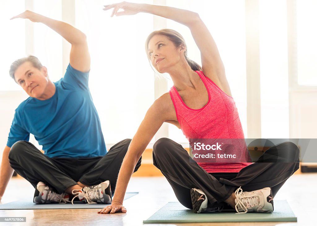 En forma pareja practicar yoga en alfombra en su casa - Foto de stock de Ejercicio físico libre de derechos