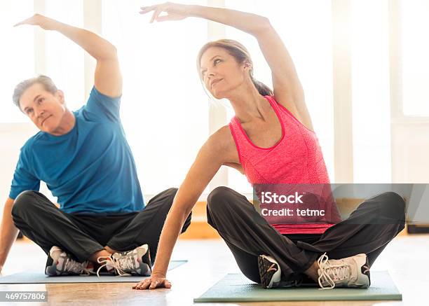 En Forma Pareja Practicar Yoga En Alfombra En Su Casa Foto de stock y más banco de imágenes de Ejercicio físico