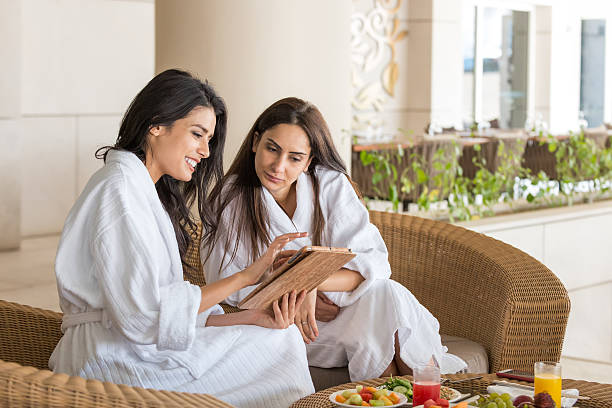 Middle Eastern Women with Computer Tablet Having Spa Meal Together stock photo