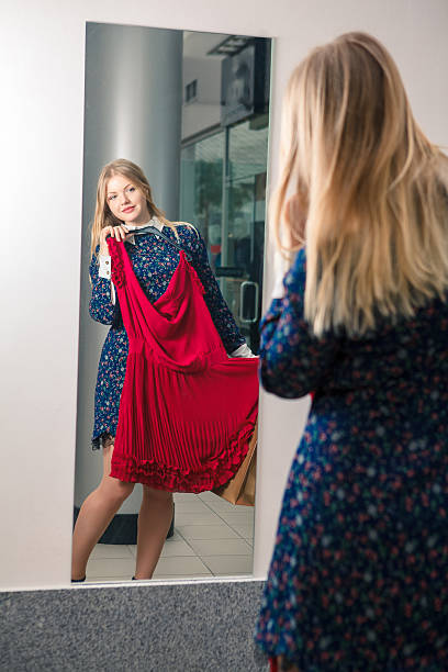 istock Woman trying on a red dress while shopping 469759236