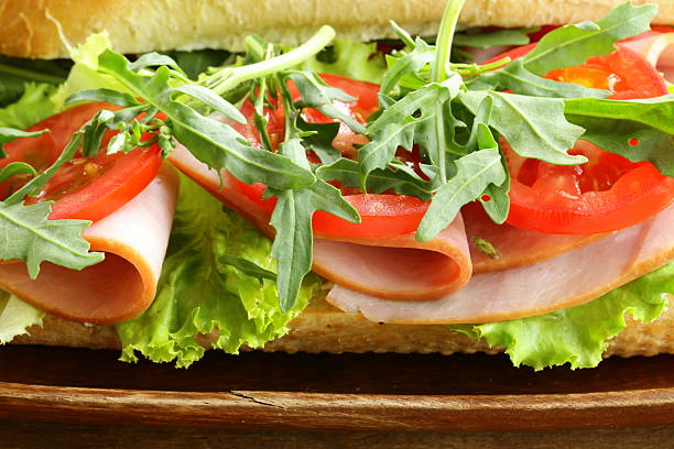 istock baguette sandwich with arugula, ham and tomatoes 469760187