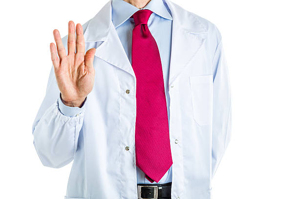 Vulcan salute gesture by doctor in white coat Caucasian male doctor dressed in white coat, blue shirt and red tie is making Vulcan salute gesture vulcan salute stock pictures, royalty-free photos & images