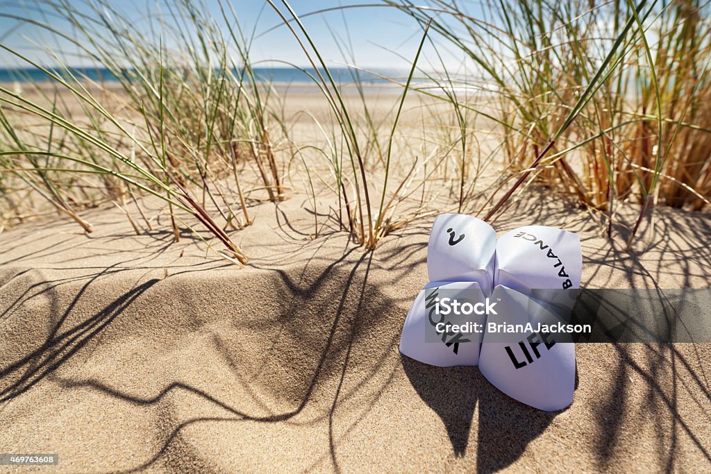 Work life balance choices Origami fortune teller on vacation at the beach concept for work life balance choices Life Balance Stock Photo